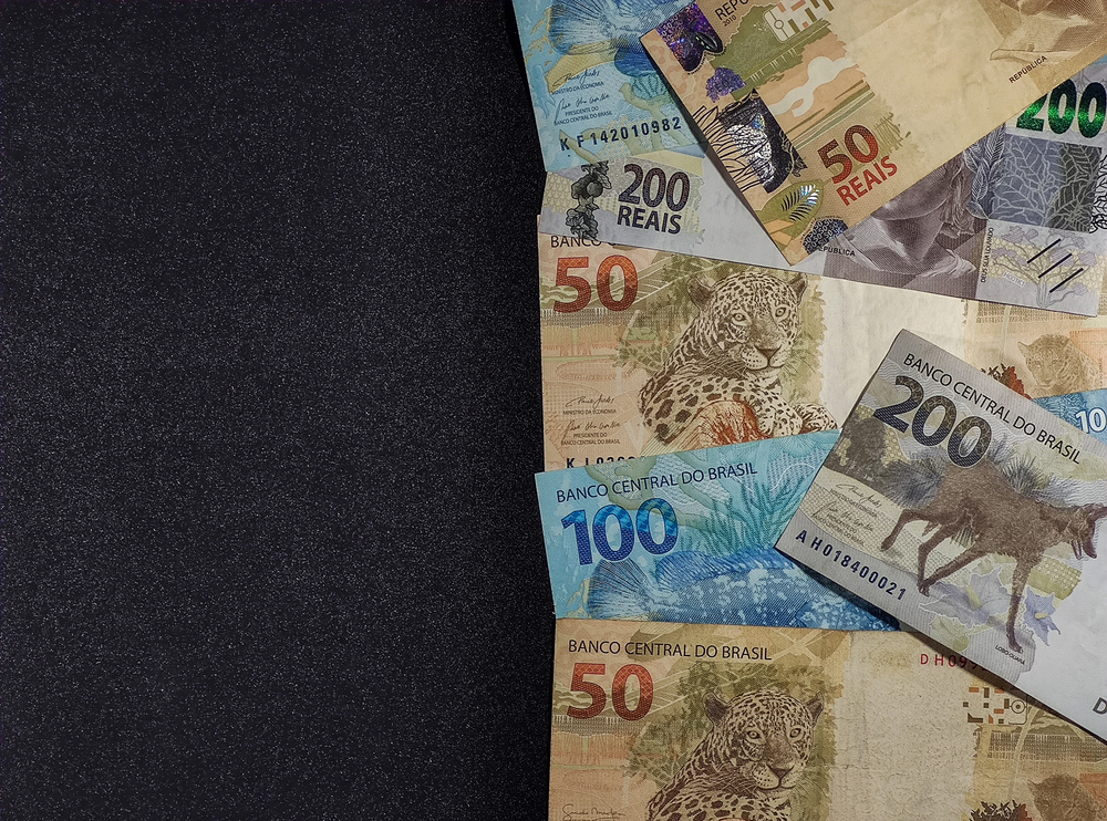 Notas de 50,100 e 200 reais em um fundo cinza